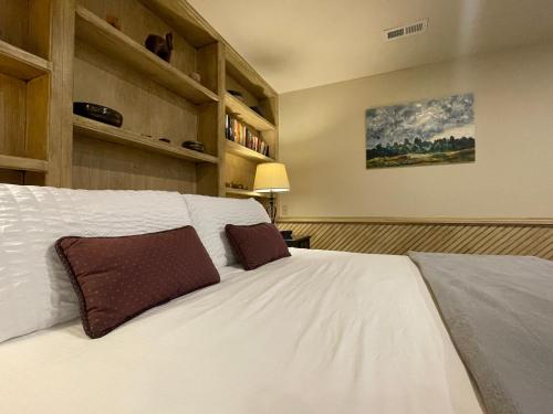 a bedroom with a large white bed with brown pillows at Couples Retreat with Hot Tub, Sauna and Steam Room in Fort Collins
