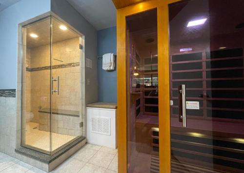 a bathroom with a shower and a glass door at Couples Retreat with Hot Tub, Sauna and Steam Room in Fort Collins