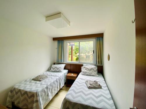 twee bedden in een kamer met een raam bij Pipa Paradise, Central, Praia do amor in Pipa