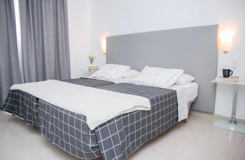 um quarto com uma cama com um cobertor preto e branco em GOLF PARK Resort em San Miguel de Abona