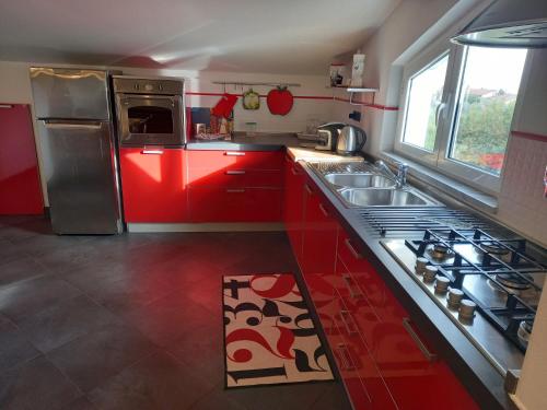 cocina roja con fregadero y fogones en CA' FRA e OLY Cinque Terre, Lerici, wifi, aria condizionata, en Castelnuovo Magra