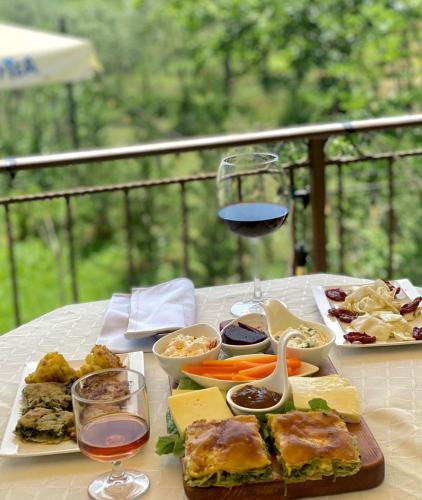 - une table avec une assiette de nourriture et un verre de vin dans l'établissement Bujtina Dumrea Rubin, à Belsh