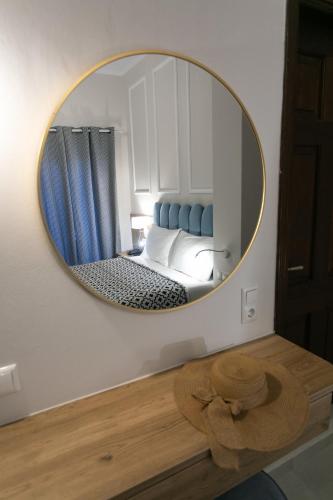 a round mirror in a room with a bed at Paradise Hotel in Parga