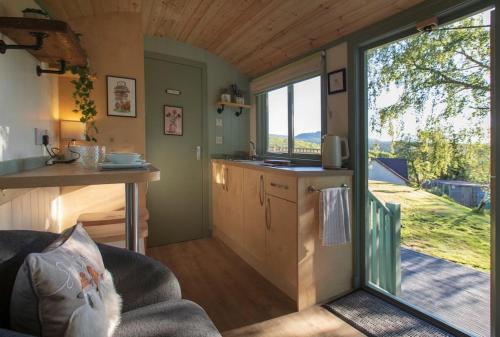 a kitchen and living room in a tiny house at Cosy Shepherds Hut with hot tub in the Scottish Highlands in Stittenham
