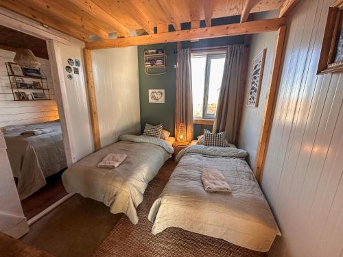 2 łóżka w małym pokoju z oknem w obiekcie Rustic Farmhouse - Narfasel w mieście Akranes