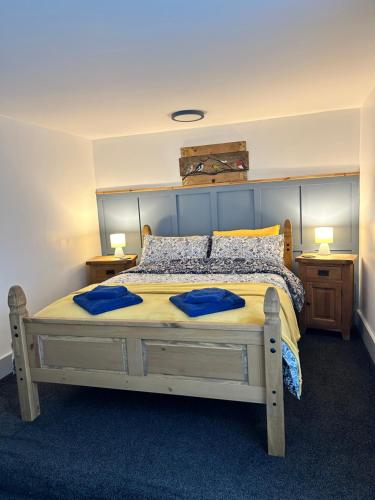 a bedroom with a large bed with two blue pillows at Cadwgan House in Rhayader