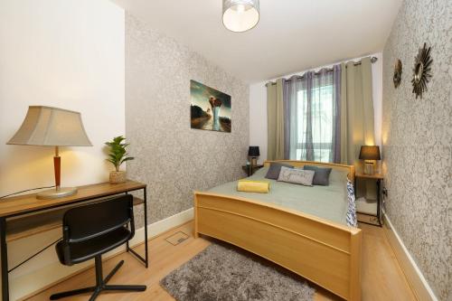 - une chambre avec un lit, un bureau et une chaise dans l'établissement St George River Apartment, à Londres