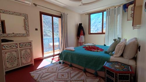 een slaapkamer met een bed met een groene deken bij Riad otos views in Imlil