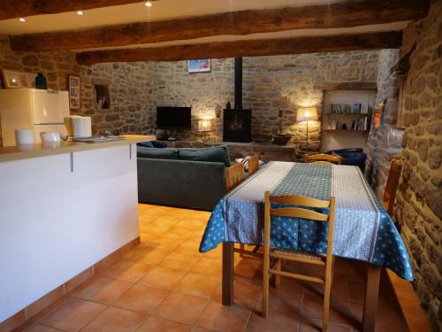 a kitchen and living room with a table and a couch at Gîte de l'Hirondelle bleue in Brech
