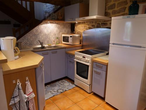 a kitchen with a white refrigerator and a stove at Gîte de l'Hirondelle bleue in Brech