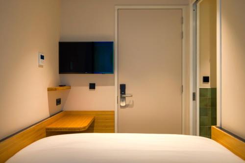 a bedroom with a bed and a flat screen tv at Poppies in Amsterdam