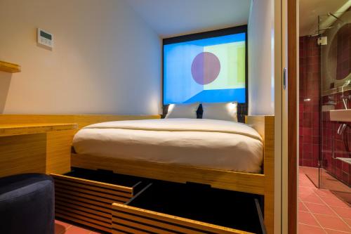 a bedroom with a bed and a large screen at Poppies in Amsterdam