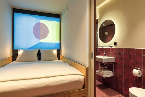 Dormitorio pequeño con cama y lavamanos en Poppies en Ámsterdam