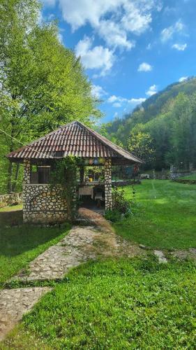 a small building with a roof in a field at Casa de vacanta Julius in Padis