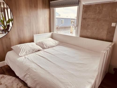 a large bed in a room with a window at Amsterdam Boathouse in Aalsmeer