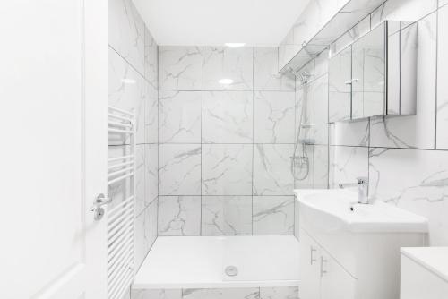 ein weißes Badezimmer mit einer Badewanne und einem Waschbecken in der Unterkunft Luxury STUDIO APART’ COVENT GARDEN FITZROVIA W1 in London