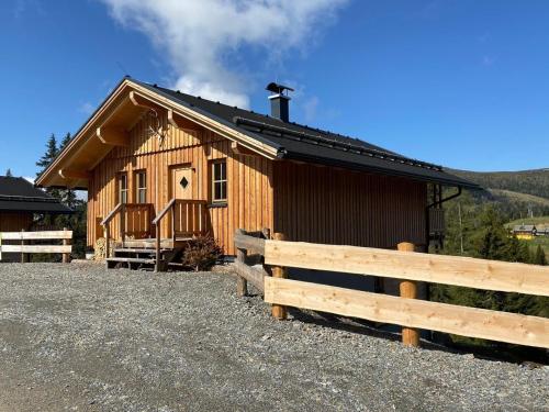 una cabaña de madera con una valla delante en Jagdhütte mit Kaminofen und Sauna en Lachtal