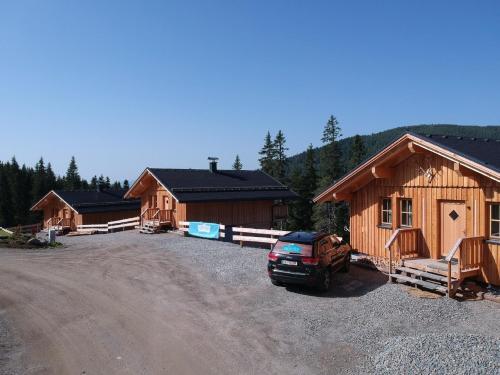 un grupo de cabañas de madera en un aparcamiento en Jagdhütte mit Kaminofen und Sauna en Lachtal