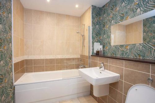 a bathroom with a sink and a tub and a toilet at Fantastic City Centre Flat in Glasgow