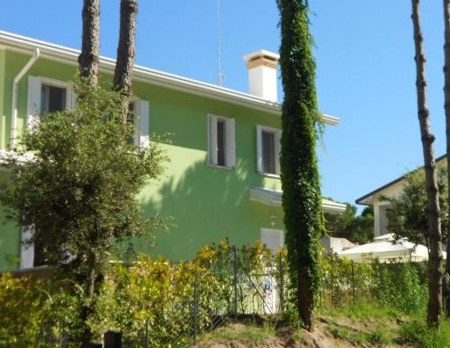 een groen huis met bomen ervoor bij Ferienhaus für 5 Personen ca 60 qm in Rosolina Mare, Adriaküste Italien Venedig und Umgebung in Rosolina