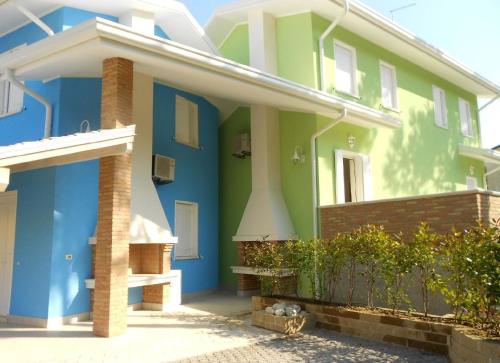 een huis met blauwe en groene verf erop bij Ferienhaus für 5 Personen ca 60 qm in Rosolina Mare, Adriaküste Italien Venedig und Umgebung in Rosolina