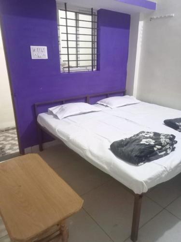 a bedroom with two beds and a purple wall at JAIN HOME STAY in Indore