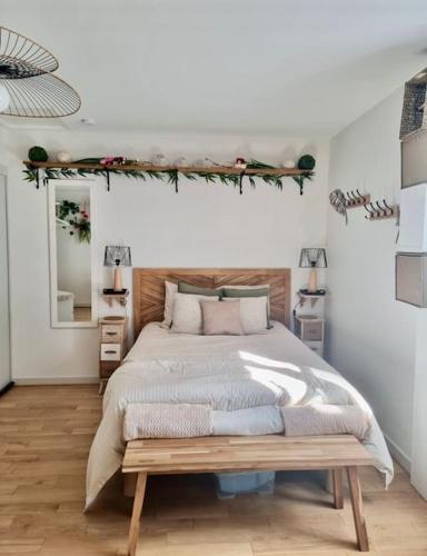 une chambre avec un grand lit et un miroir dans l'établissement Studio le coquelicot, à Moulins