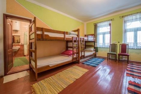 a room with three bunk beds in a room at Edukativ Szállás in Skorenovac