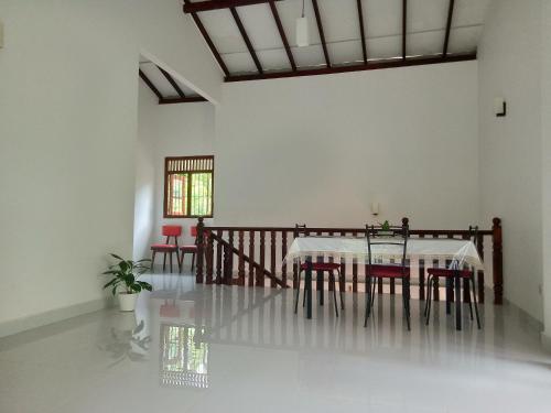 a dining room with a table and red chairs at Evi's Place in Galle