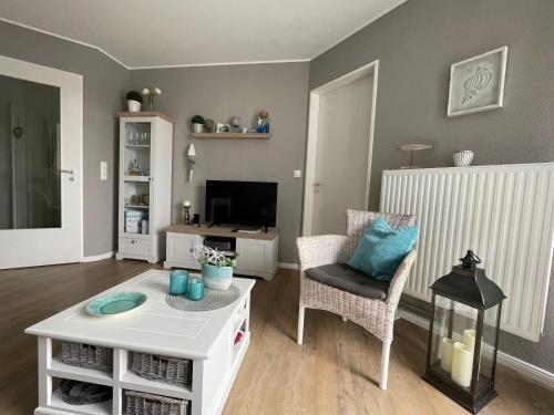 格洛米茨的住宿－"Haus Atlantic" - Wohnung "StrandGut"，客厅配有白色咖啡桌和电视