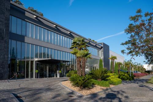 an office building with a palm tree in front of it at Vila Gale Evora in Évora