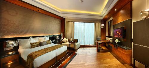 a hotel room with a large bed and a desk at Crowne Plaza New Delhi Rohini by IHG in New Delhi