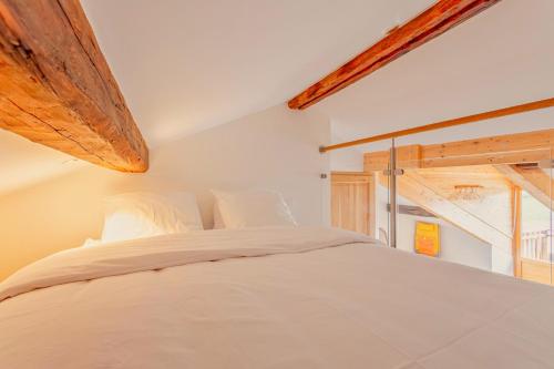 a bedroom with a white bed and a window at Chalet Marijo: Sauna & Charme Alpin in Saint-Marcel