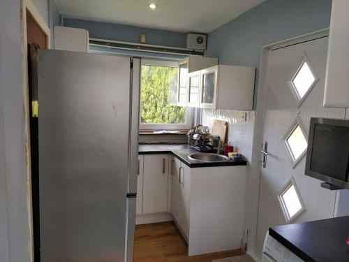 a small kitchen with white cabinets and a sink at Studio Flat in Edinburgh