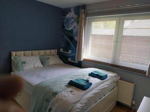 a bedroom with a bed with two blue bags on it at Double Ensuite room, 1-minute walk to bus stop in Edinburgh