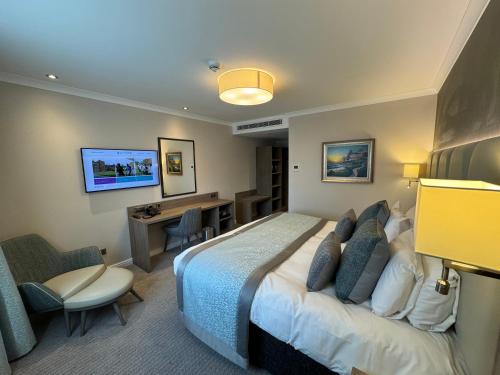 a hotel room with a bed and a desk at Ashorne Hill Leamington Spa in Leamington Spa