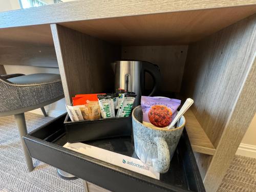 a drawer in a desk with a cup of food at Ashorne Hill Leamington Spa in Leamington Spa
