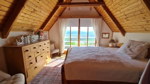ein Schlafzimmer mit einem großen Bett und einem großen Fenster in der Unterkunft Mont Blanc Chalet in Grandevent