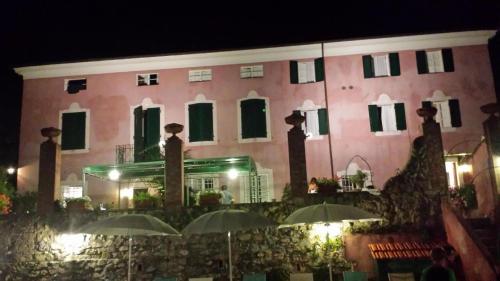 een groot roze gebouw met parasols ervoor bij Großes Ferienhaus in Bargecchia mit Privatem Pool in Corsanico-Bargecchia
