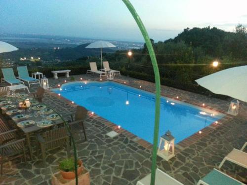 een zwembad met een tafel en stoelen en een parasol bij Großes Ferienhaus in Bargecchia mit Privatem Pool in Corsanico-Bargecchia