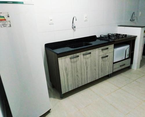 a kitchen with a sink and a stove at AP Confortável San Inácio in Santo Ângelo