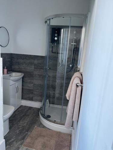 uma casa de banho com um chuveiro, um WC e um lavatório. em Stylish and Spacious Wi-Fi Smart TV Tea and coffee em Kettering