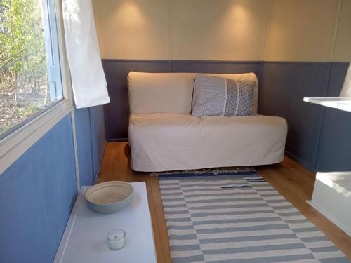 un sofá en una habitación con ventana en Nieuw ingerichte pipowagen bij Zutphen en IJssel! en Vierakker