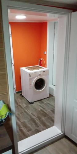 a washing machine in a room with an orange wall at Filipov Konak in Bajina Bašta