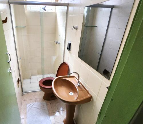 a bathroom with a toilet and a sink and a shower at Guarany Hotel Express in João Pessoa