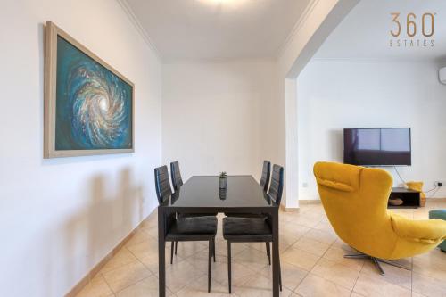 圣朱利安斯Stylish & Cosy 2BR Apt in the Heart of St' Julians by 360 Estates的一间带桌子和黄色椅子的用餐室