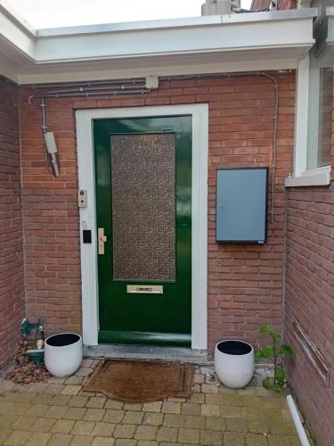una puerta verde con dos macetas blancas delante de ella en Zaan Corner Hotel en Koog aan de Zaan