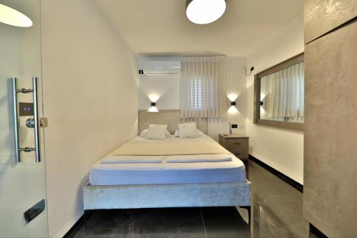 a bedroom with a large bed in a room at שקיעה בים - דירות נופש יוקרתיות עם ג'קוזי ונוף לים in Haifa