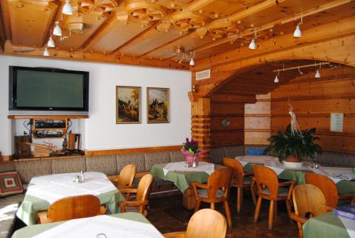 a dining room with tables and a flat screen tv at Frühstückspension Kirchenwirt in Obervellach