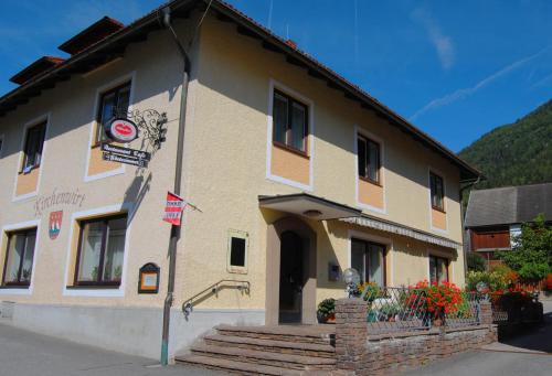 a building with a staircase in front of it at Frühstückspension Kirchenwirt in Obervellach
